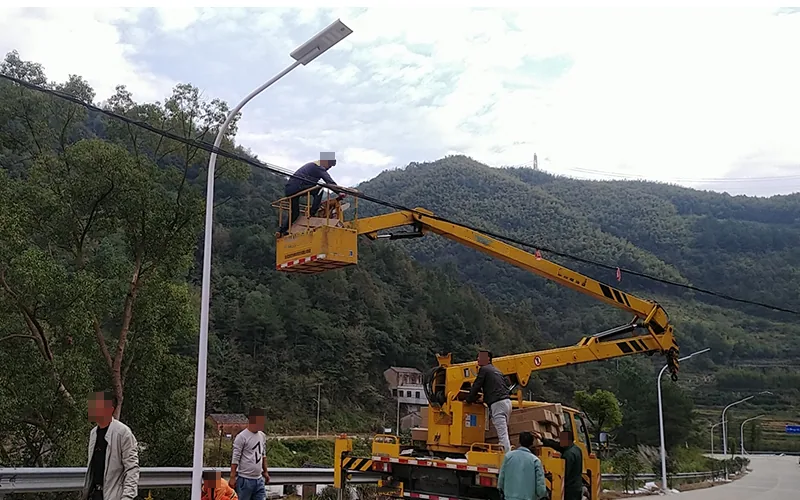 Crew installing solar street lights along a mountain road
